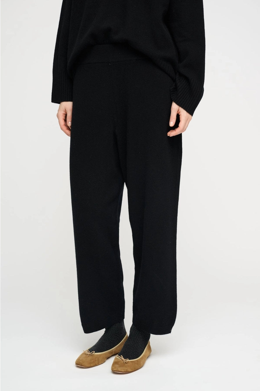 Black wool pants by Moshi Moshi, minimalist tailored fit, soft natural woven texture, seasonless wardrobe essential.