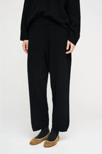 Black wool pants by Moshi Moshi, minimalist tailored fit, soft natural woven texture, seasonless wardrobe essential.