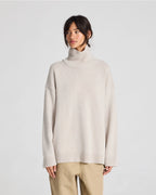 Beige merino wool roll-neck (turtleneck) sweater, soft fine knit, timeless silhouette. Inspired by quiet luxury, minimalist styling.